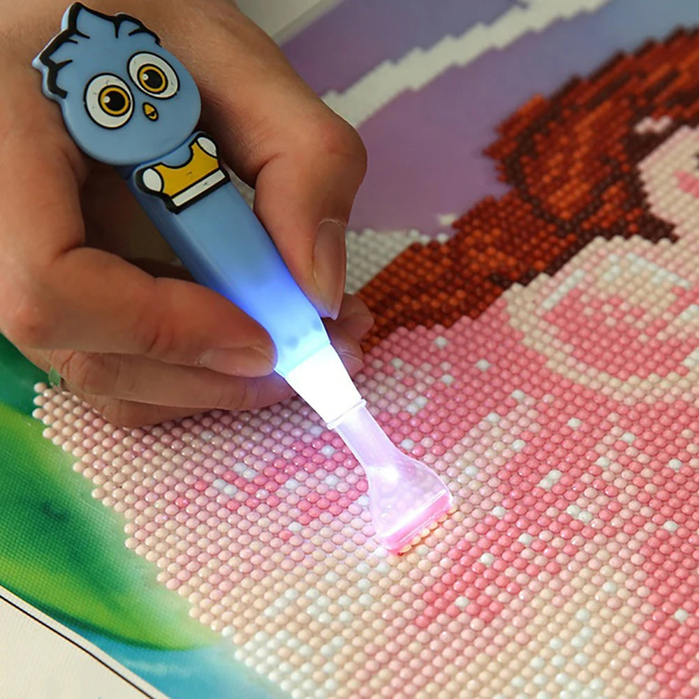 Precision crafting with a blue LED diamond painting pen in a cartoon theme—an essential tool for diamond art lovers. Multi-crystal applicator attached. 