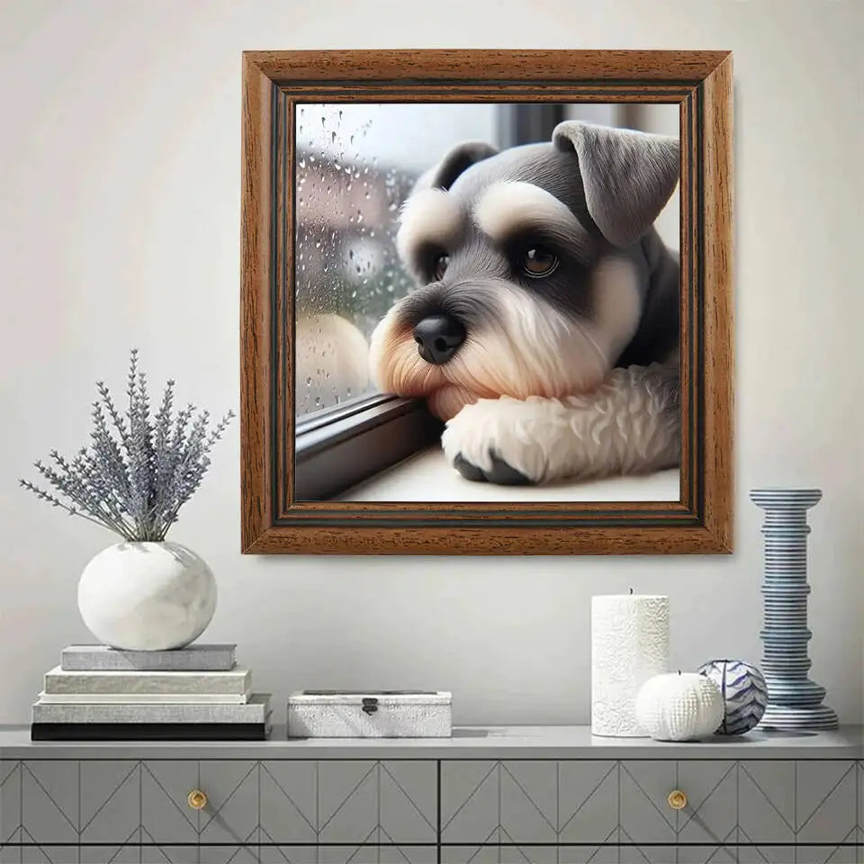 A little terrier puppy sits with his face rested up against a window on a rainy day and stares into the distance. His expression is forlorn, as though he is eagerly awaiting his master's return. This poignant image captures intense emotion and realism. Set in a brown frame and mounted in a living room.