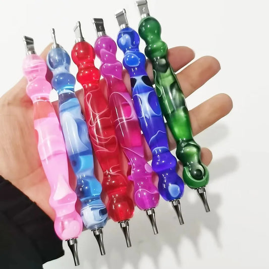 Set of colorful diamond drill pens held in a hand against a white background